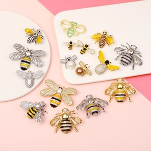 Collection of luxury bee brooches with enamel, pearls, and zircons on a pastel background