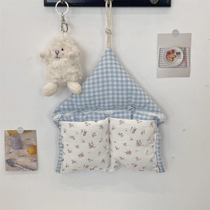Detail of macaron plaid wall organizer with lace floral pockets and plush sheep charm