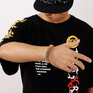 Men's gold spiral spring bracelet shown on wrist with a bold streetwear style
