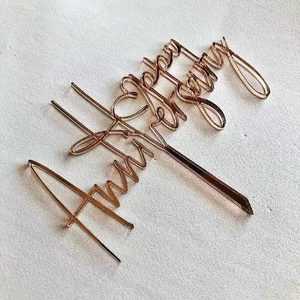 Rose gold acrylic Happy Anniversary cake topper on a light textured background