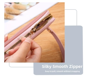 Macro detail of pink pebbled leather wallet featuring a smooth gold metallic zipper closure