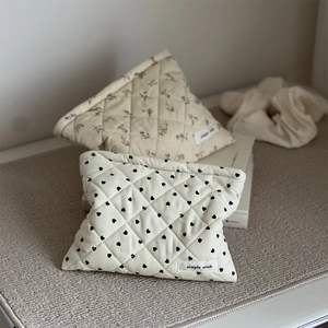 Quilted corduroy pouch detail featuring floral and heart patterns with simple wish label