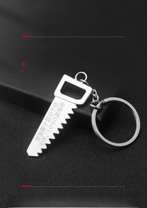Detailed view of silver metal saw-shaped keychain on black leather texture
