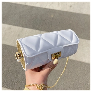 Detail of white quilted cylindrical bag with gold chain strap and pearl decor