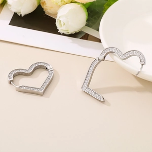 Dettaglio di orecchini a cerchio a cuore in argento con zirconi micro-incastonati