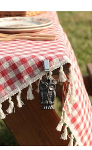 Détail d'un poids de nappe vintage en fonte en forme de hibou sur tissu à carreaux