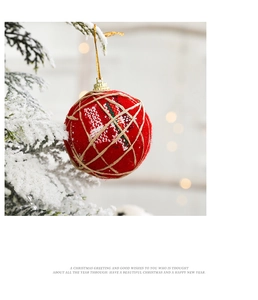 Detail of red velvet Christmas ball with hemp rope wrap hanging on a snowy tree branch