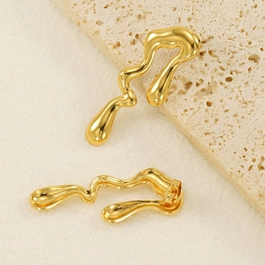 Macro detail of 18K gold plated irregular fluid water drop earrings on textured stone