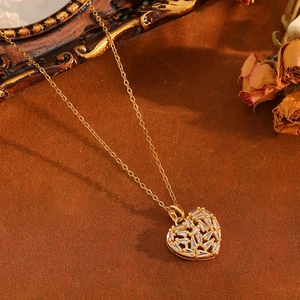 Vue macro d'un pendentif cœur doré avec oxydes de zirconium sur fond vintage brun