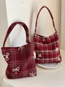 Detail of red plaid wool handbags with white embroidered bows in vintage style