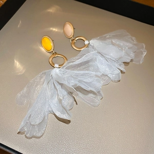 Detailed close-up of large fabric flower earrings with yellow and pink gemstones