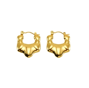 Detailed close-up of golden chunky hoop earrings with textured vintage croissant design