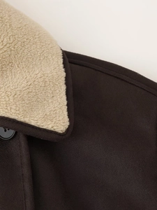 Detail of dark brown faux suede jacket with beige shearling collar and black buttons