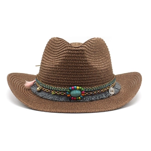 Détail d'un chapeau de cow-boy en paille bohème avec bande perlée et pierre turquoise