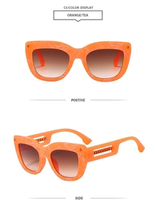 Macro view showing stylish orange marble cat-eye sunglasses with metal chain temple detail