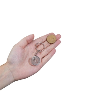 DIY silver stainless steel spiral ball keychain pendant shown with coin for scale