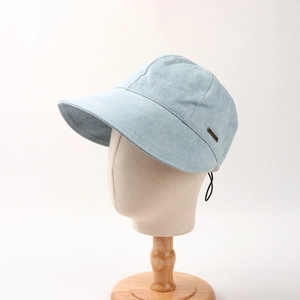 Close-up of light blue denim sun hat texture with metallic logo and windproof rope