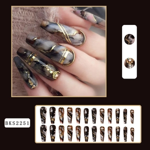 Detailed view of long coffin nails featuring black brown marble pattern with gold lines