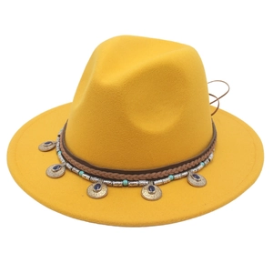 Dettaglio di cappello in lana boho con fascia intrecciata e pendenti dorati vintage