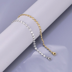 Sparkling 18K gold and silver snowflake chain bracelets displayed on a neutral pedestal