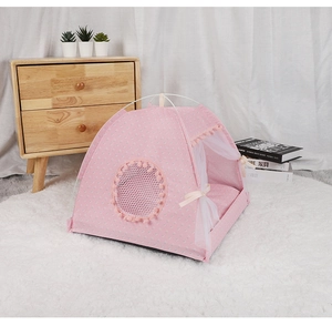 Pink polka dot pet tent with lace curtains and pompom details on white plush carpet