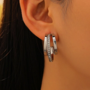 Modern silver multi-layered C-shape earrings with inlaid rhinestones on a female model