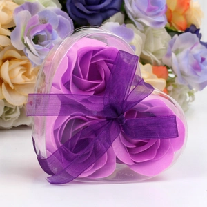 Detail of a heart-shaped gift box with three purple soap roses and a matching ribbon bow