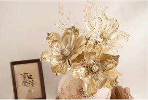 Detailed close-up of champagne gold magnolia flower with glitter accents and beaded stems