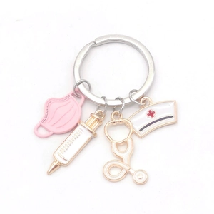 Medical keychain with pink mask, syringe, stethoscope, and nurse hat charms on white back