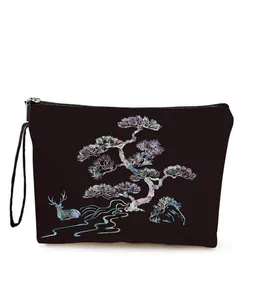 Detail of pine and deer pattern on black multipurpose pouch with zipper and wrist strap