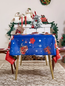 Close-up of blue Christmas tablecloth with Santa, reindeer and red borders in a festive room