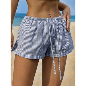 Blue and white striped linen shorts with elastic drawstring waist on beach background