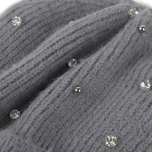Détail macro du tissu tricoté gris avec strass étincelants et perles argentées déco