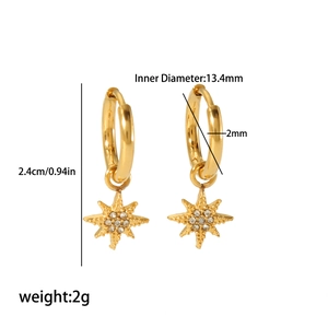 Detail view of gold star dangle hoop earrings with sparkling cubic zirconia inlay