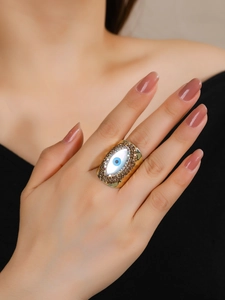 14K gold-plated Evil Eye ring with shell inlay and brown crystal accents on finger
