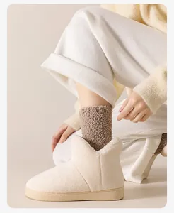 Gros plan de pantoufles douillettes en polaire crème avec d'épaisses chaussettes en tricot