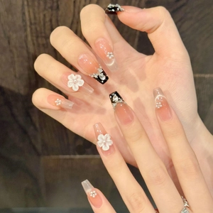 Detailed close-up of handmade press-on nails with 3D white flowers and zircon rhinestones