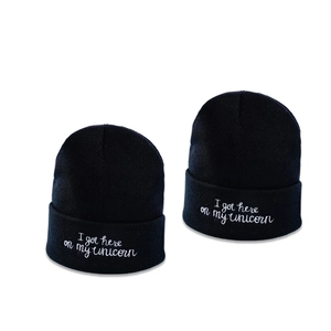 Minimalist black knit beanie with white embroidered slogan I got here on my unicorn