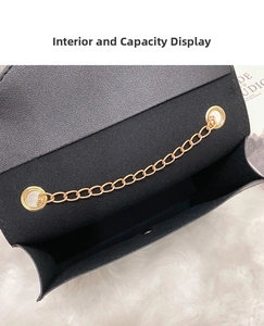 Interior view of black leather crossbody bag with gold chain and plush white background
