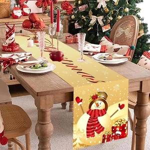 Chemin de table de Noël doré avec motif bonhomme de neige rouge et vaisselle de fête chic