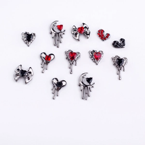 Gothic silver alloy nail art charms set with red and black rhinestones on white base
