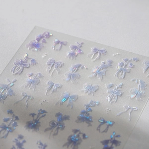 Holographic bow and flower nail art stickers with iridescent laser effect on white background