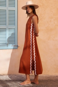 Detail of terracotta sleeveless dress featuring white ric-rac trim and side slit detail