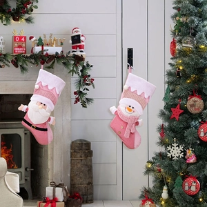 Detail of pink Nordic Christmas stockings with Santa and snowman by the fireplace