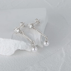 Detail view of S925 silver asymmetric earrings with clear gemstone and white pearls