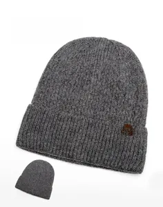 Close-up of gray knit beanie featuring ribbed texture and a brown snowflake leather patch