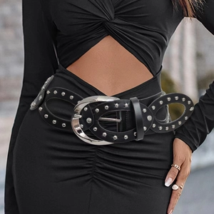 Detail of wide black PU leather belt with silver studs and large oval buckle for women