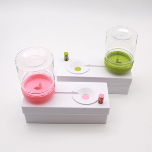 Pink and green automatic paintbrush cleaner with water cycle system on white background