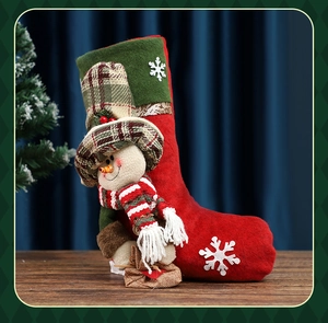 Detail of red and green felt Christmas stocking with a 3D plush snowman and snowflake decor