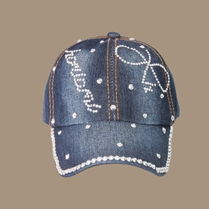 Detail of denim baseball cap with sparkling rhinestones and embroidered bow decoration